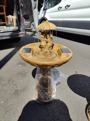 Lot 106 - Sand coloured solar powered bird bath fountain with figures holding umbrella