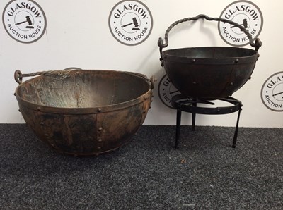 Lot 1 - 2 heavy metal cauldrons and a stand in various sizes