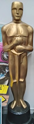 Lot 37 - Tall prop decorative oscar style statue in gold finish with black base