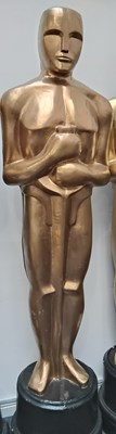 Lot 39 - Tall prop decorative oscar style statue in gold finish with black base