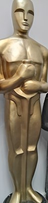 Lot 41 - Tall prop decorative oscar style statue in gold finish with black base