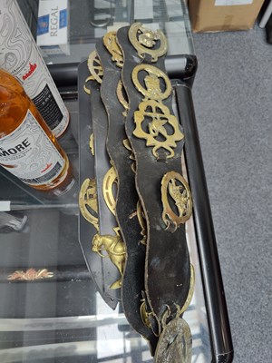 Lot 146 - 4 leather straps holding a qty of horse brass